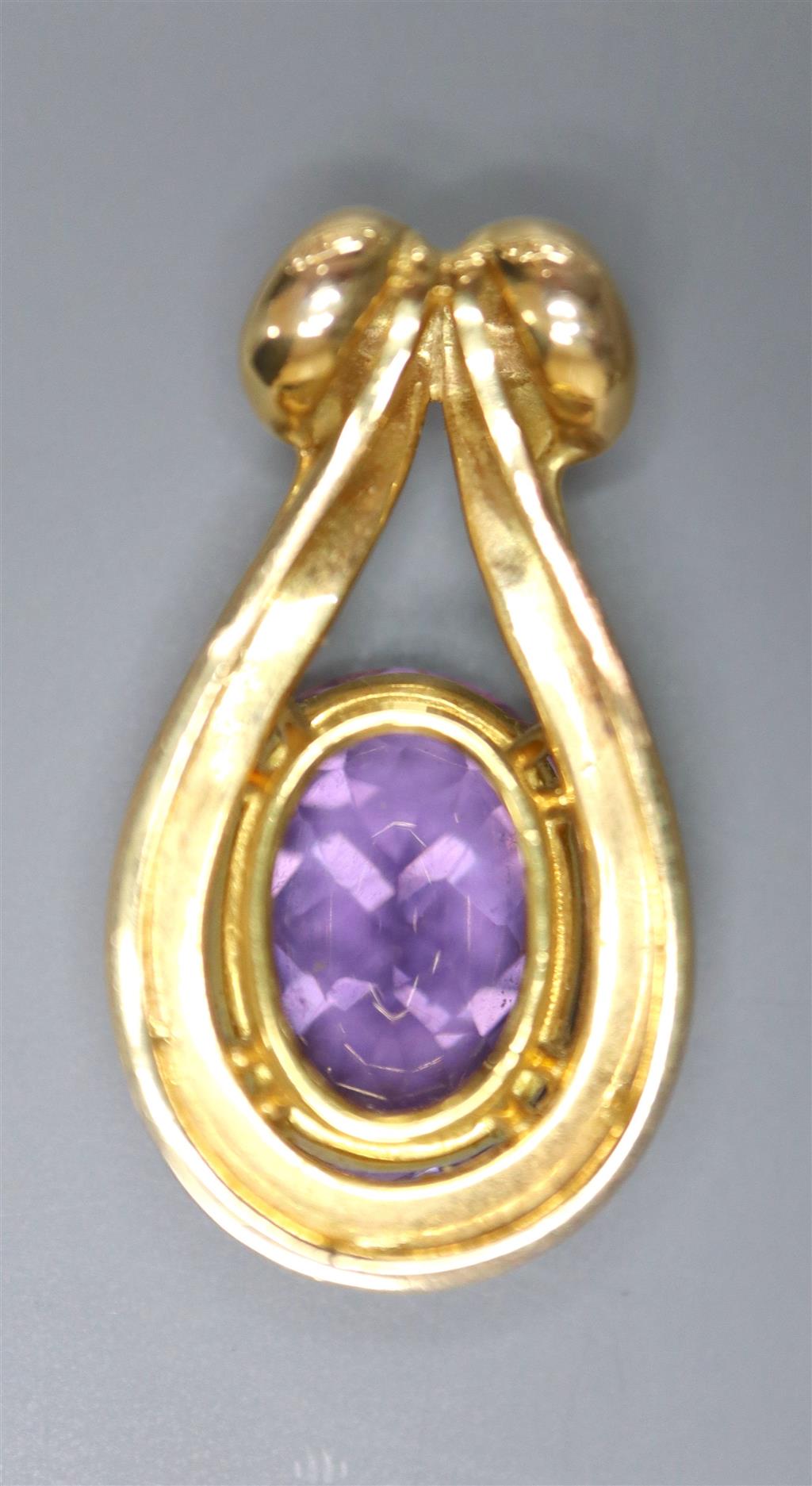 A modern yellow metal and oval cut amethyst set pendant, 31mm, gross 9 grams.